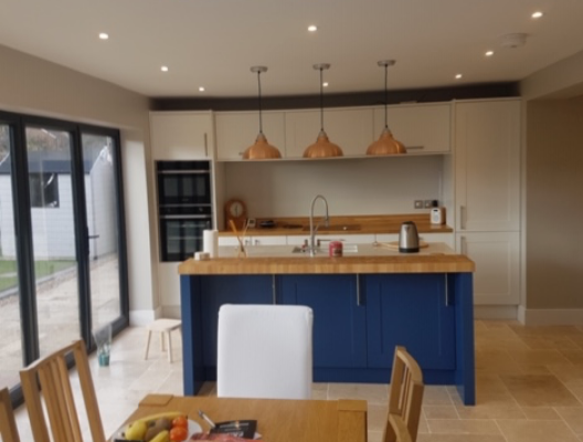 Fitted kitchen with navy island and timber worktop