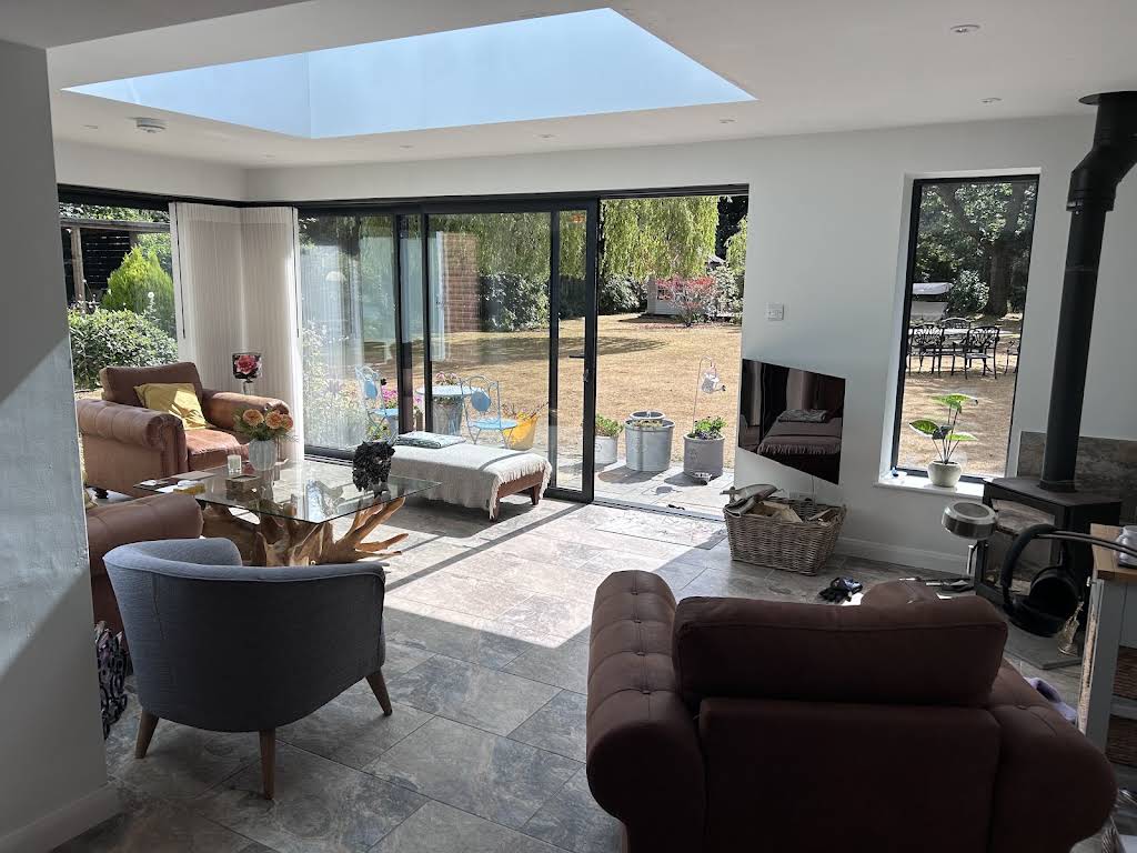 Bright completed interior with rooflight and dark framed doors